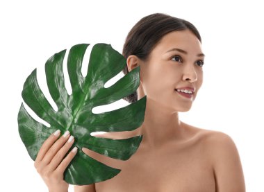 Beyaz arka planda palmiye yaprağı olan güzel Asyalı kadın, yakın plan.