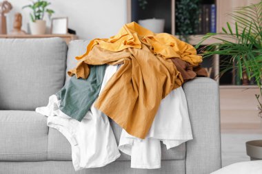 Oturma odasındaki kanepede bir yığın kirli giysi.