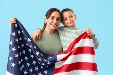 Mavi arka planda Amerikan bayrağı olan küçük bir çocuk ve annesi. Gaziler Günü kutlamaları