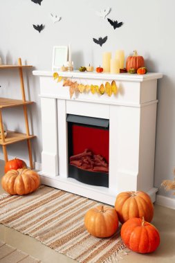 Cadılar Bayramı balkabakları ve mumlar oturma odasında şöminenin üstünde.