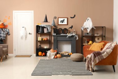 Cadılar Bayramı için kanepe ve şömine rafıyla dekore edilmiş oturma odasının içi.