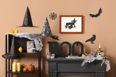 Cadılar Bayramı için dekore edilmiş oturma odasının içinde raf ünitesi ve şömine rafı var.