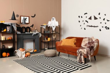 Cadılar Bayramı için kanepe ve şömine rafıyla dekore edilmiş oturma odasının içi.