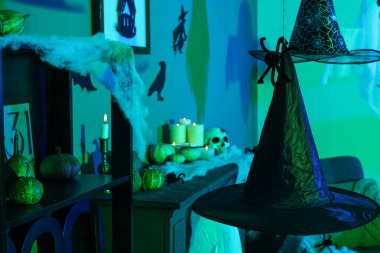 Cadılar Bayramı için dekore edilmiş karanlık odada asılı cadı şapkaları.