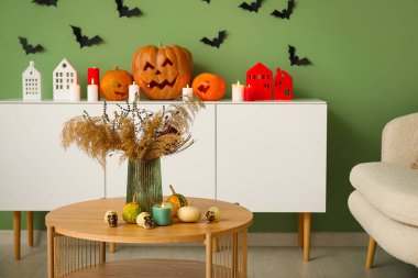 Çimenli vazo, Cadılar Bayramı balkabağı, kafatası ve mum oturma odasında.