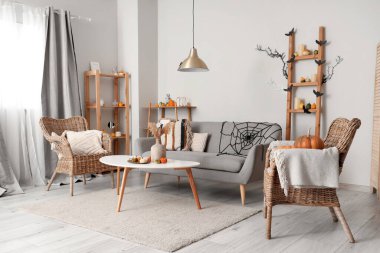 Cadılar Bayramı için dekore edilmiş oturma odasının içi kanepe ve koltuklarla dolu.