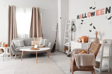 Cadılar Bayramı için dekore edilmiş oturma odasının içi kanepe ve koltukla dolu.