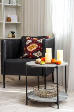 Cadılar Bayramı için masa ve koltukla dekore edilmiş aydınlık oturma odasının içi.