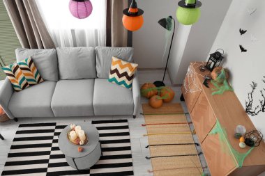 Cadılar Bayramı için dekore edilmiş oturma odasının içi kanepe ve çekmecelerle dolu.