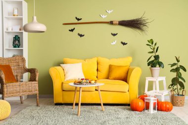 Cadılar Bayramı için sarı kanepe ve koltuk ile dekore edilmiş oturma odasının içi.