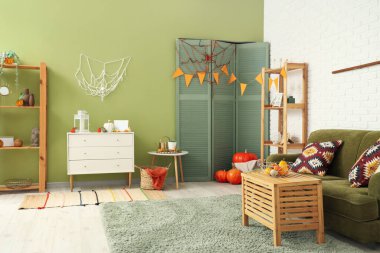 Cadılar Bayramı için yeşil kanepeyle dekore edilmiş oturma odasının içi.