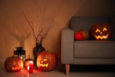 İçinde kanepe ve Cadılar Bayramı balkabağı olan karanlık bir oturma odası.