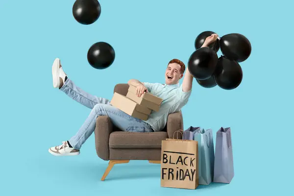 Happy Young Man Shopping Bags Boxes Balloons Sitting Armchair Blue — Stock Photo, Image
