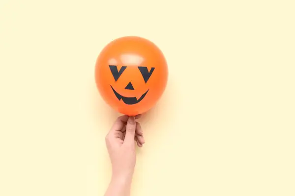 Kobieta Ręka Śmieszne Halloween Pomarańczowy Balon Żółtym Tle — Zdjęcie stockowe