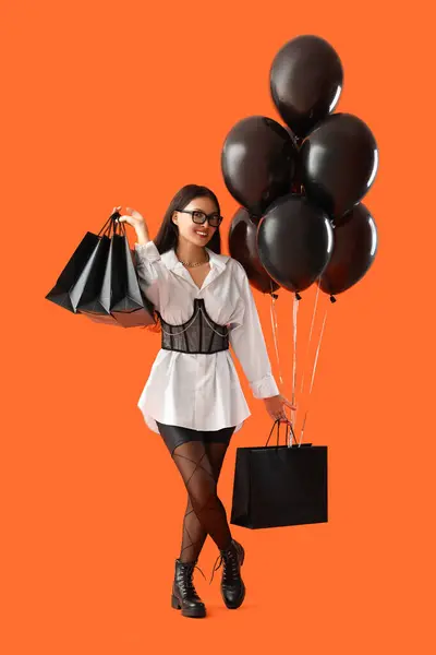 Mladá Asijská Žena Nákupními Taškami Balónky Oranžovém Pozadí Černý Pátek — Stock fotografie