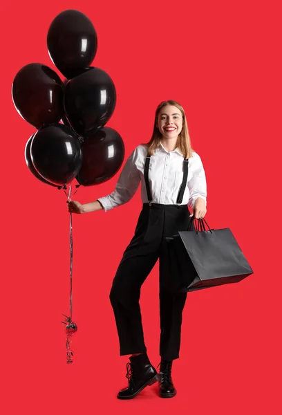 Ung Kvinna Med Shoppingväskor Och Ballonger Röd Bakgrund Black Friday — Stockfoto