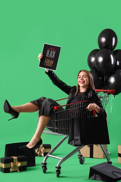 Junge Frau Mit Karte Einkaufswagen Auf Grünem Hintergrund Black Friday — Stockfoto