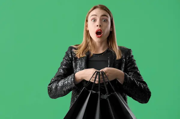 Geschokt Jonge Vrouw Met Boodschappentassen Groene Achtergrond Zwarte Vrijdag Verkoop — Stockfoto