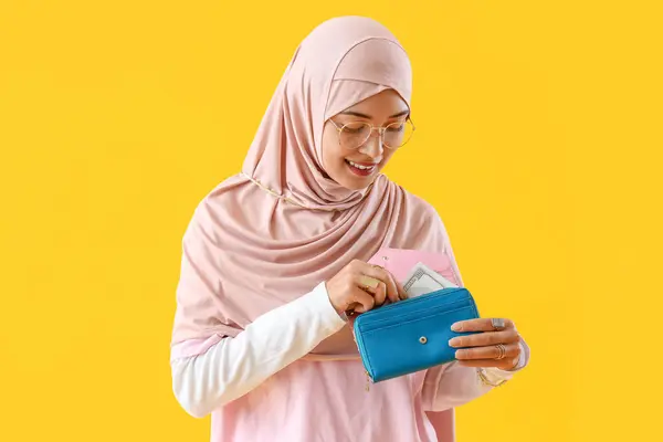Junge Muslimin Mit Geldbörse Auf Gelbem Hintergrund — Stockfoto