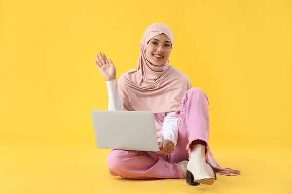 Jonge Moslimvrouw Met Laptop Zittend Gele Achtergrond — Stockfoto