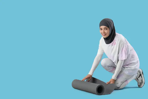 Deportiva Mujer Musulmana Desplegando Alfombra Fitness Sobre Fondo Azul —  Fotos de Stock