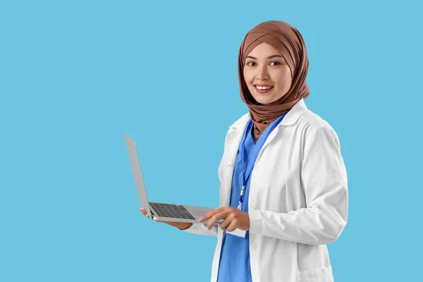 Médico Musulmán Femenino Con Portátil Sobre Fondo Azul —  Fotos de Stock