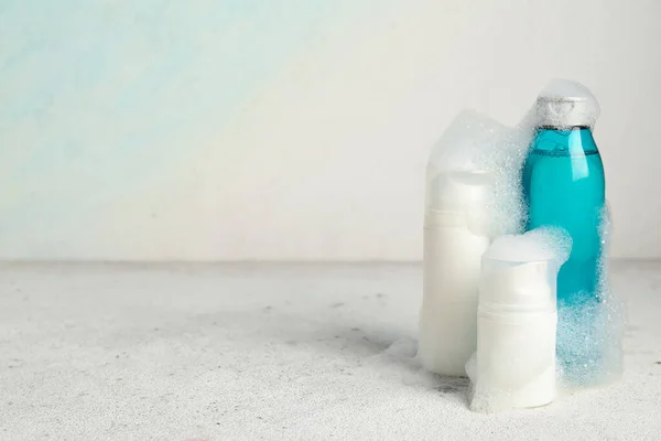 Bottles of shower gel with bath foam on white grunge background