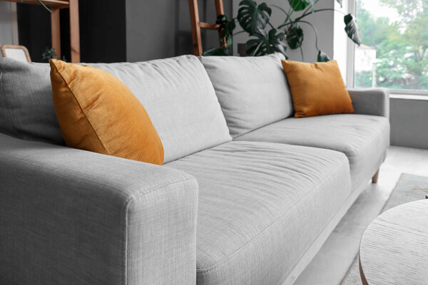 Grey sofa with cushions in living room