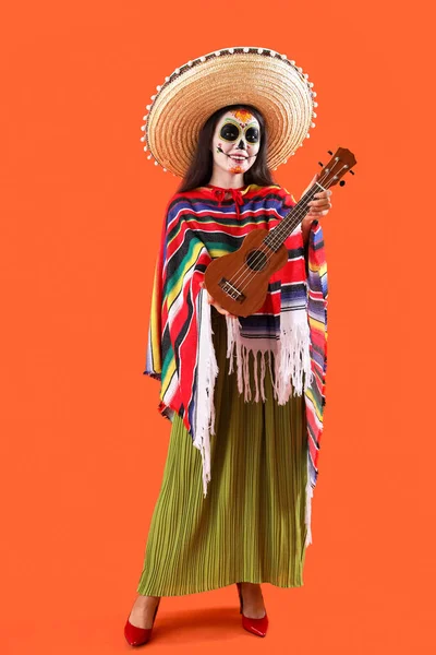 オレンジ色の背景にギターでハロウィーンのためのドレスを着た美しい女性 — ストック写真