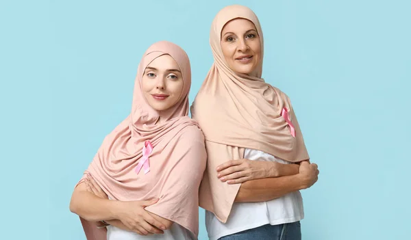青い背景にピンクのリボンを持つイスラム教徒の女性 乳がん認知コンセプト — ストック写真
