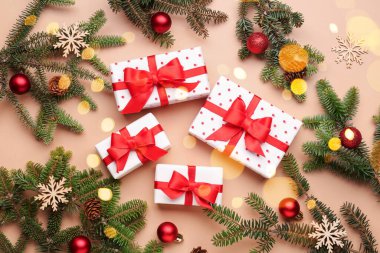 Noel hediyeleri, köknar dalları ve bej arka planda dekor, üst görünüm