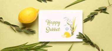 Dört tür (lulav, hadas, arava, etrog) ve sarı arkaplanda Mutlu SUKKKOT yazılı tebrik kartı