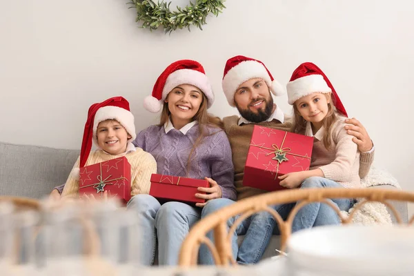 Feliz Família Chapéus Papai Noel Com Presentes Natal Sentados Sofá — Fotografia de Stock