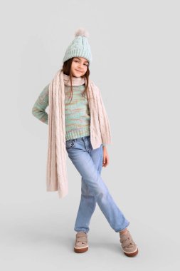 Leylak arka planında kışlık giysiler içinde şirin küçük bir kız.