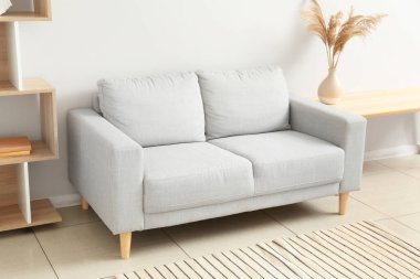 Stylish grey sofa in interior of living room