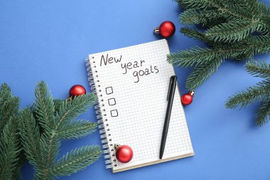 Yapılacaklar listesi boş olan defter, Noel baloları ve mavi arka planda köknar dalları
