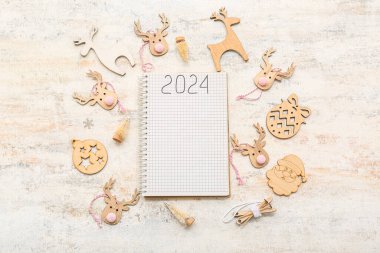 2024 yazılı defter ve arka planda ahşap Noel süslemeleri