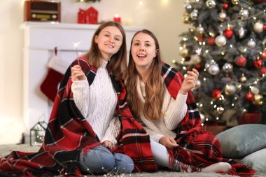 Evde Noel havai fişekleri olan genç kız kardeşler.