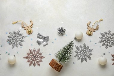 Topları ve beyaz arka planda kar taneleri olan Noel ağacı