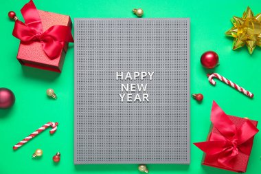 Yeni Yıl Mutlu ve yeşil arkaplan üzerine Noel süslemeleri içeren tahta