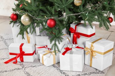 Noel ağacının altında topları ve parlak ışıkları olan hediye kutuları, yakın plan.
