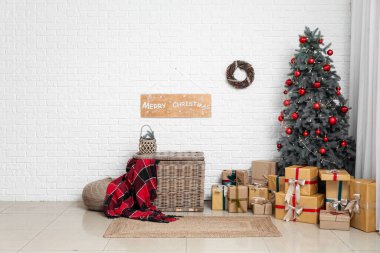 İçinde Noel ağacı, hediye kutuları, hasır sepeti ve dekor olan oturma odası.