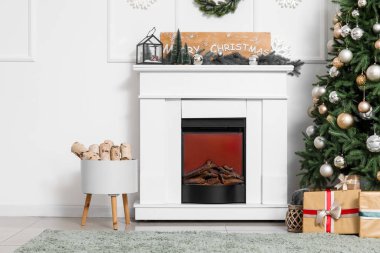 İçinde Noel ağacı, hediye kutuları ve şöminesi olan oturma odası.