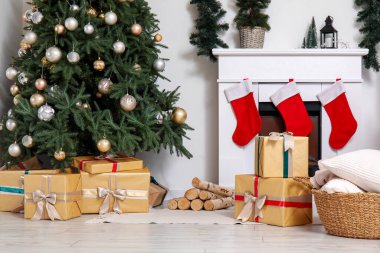 İçinde Noel ağacı, hediye kutuları ve şöminesi olan oturma odası.