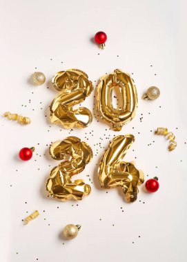 Şekil 2024 balonlardan, Noel süslemelerinden ve beyaz arka planda konfetilerden yapılmıştır.