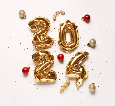 Şekil 2024 balonlardan, Noel süslemelerinden ve beyaz arka planda konfetilerden yapılmıştır.
