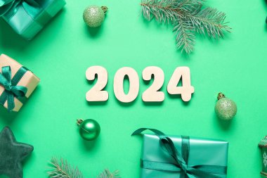 Noel süslemeleri ve yeşil arka planda hediye kutuları ile 2024