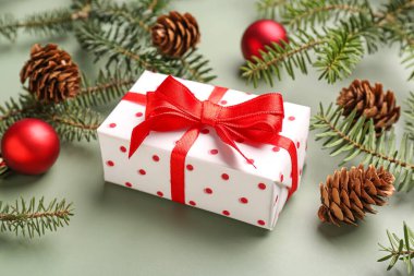 Hediye kutulu Noel ağacı dalları, gri arka planda toplar ve koniler