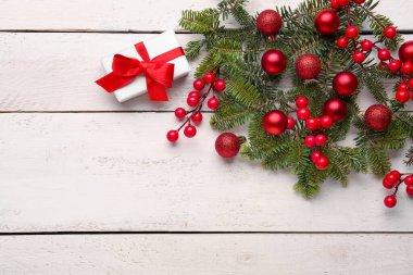 Hediye kutulu Noel ağacı dalları ve beyaz ahşap arka planda Rowan.