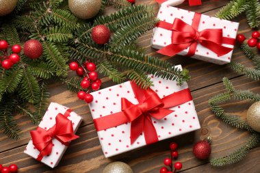Hediye kutularıyla Noel ağacı dalları ve ahşap arka planda Rowan